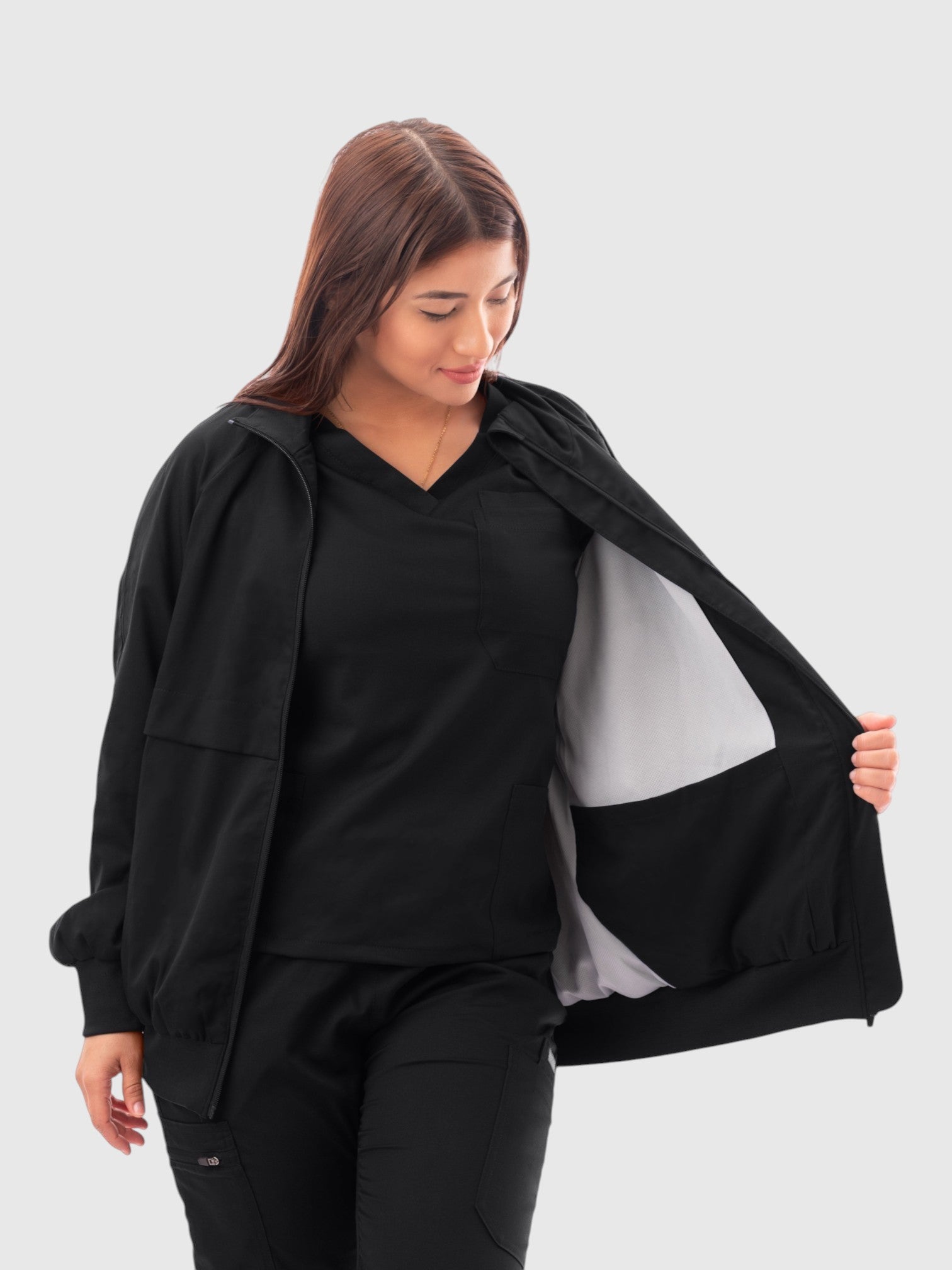 Kotyss women's black scrub jacket with a high windbreaker neck, ribbed cuffs, and a white interior lining.