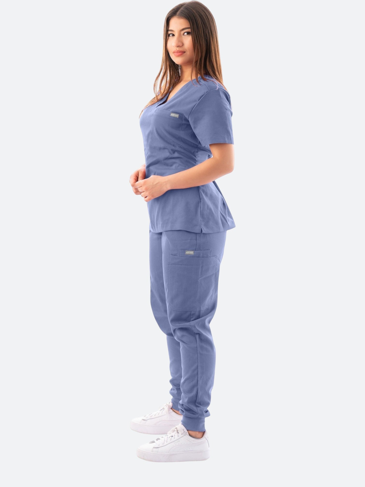 Kotyss women's blue V-neck scrub top and jogger pants set with multiple pockets on a model