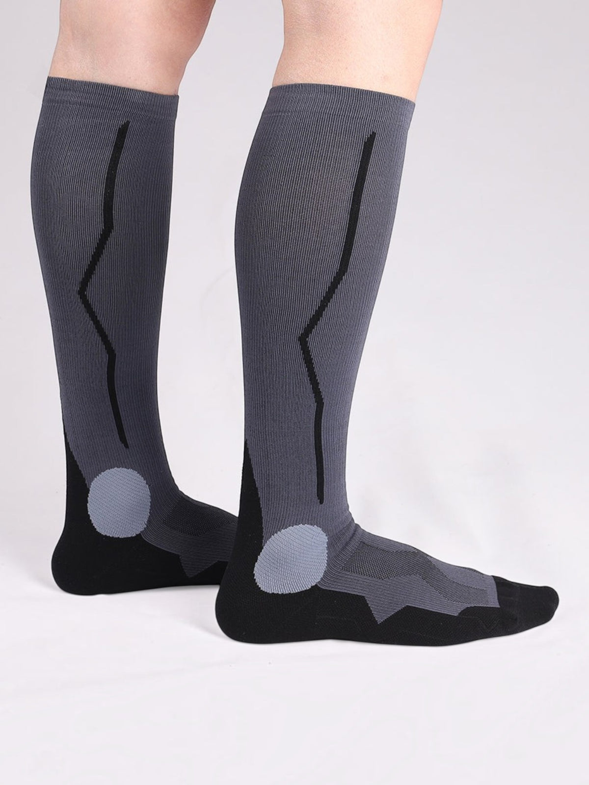 Kotyss unisex knee-high compression socks in grey and black with seamless breathable fabric and padded heel support.