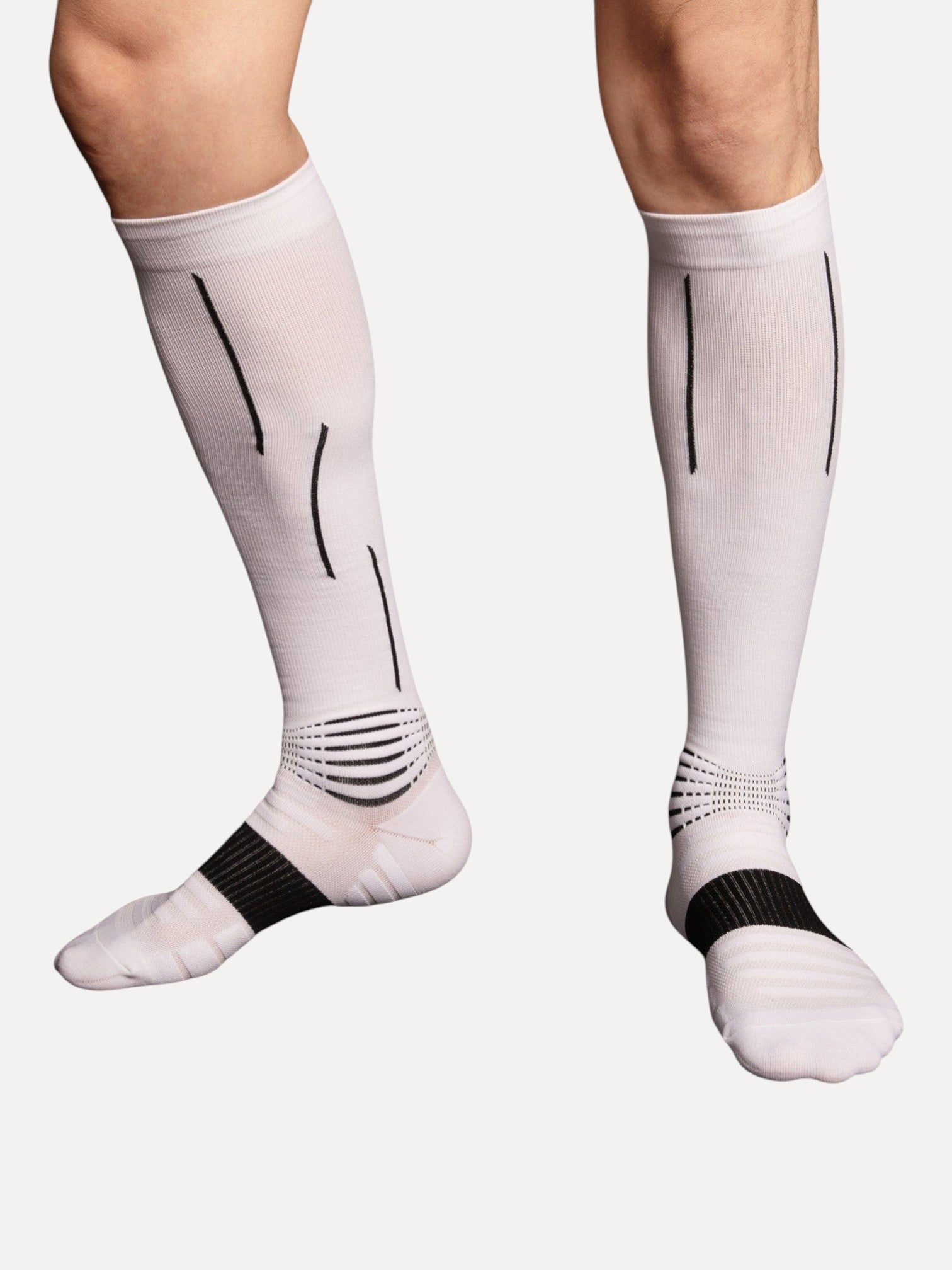 Kotyss white knee-high athletic compression socks with black accent lines and reinforced heel and toe padding