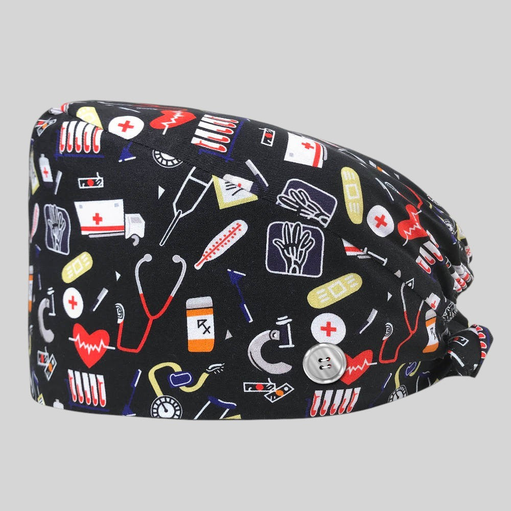Kotyss unisex scrub cap in black with colorful medical equipment print, featuring adjustable back ties and side buttons.