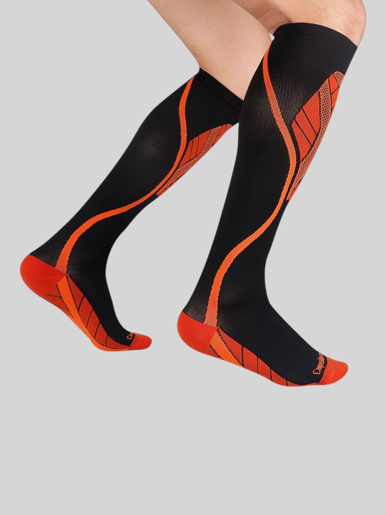 Kotyss black and orange knee-high athletic compression socks with seamless breathable fabric and padded support