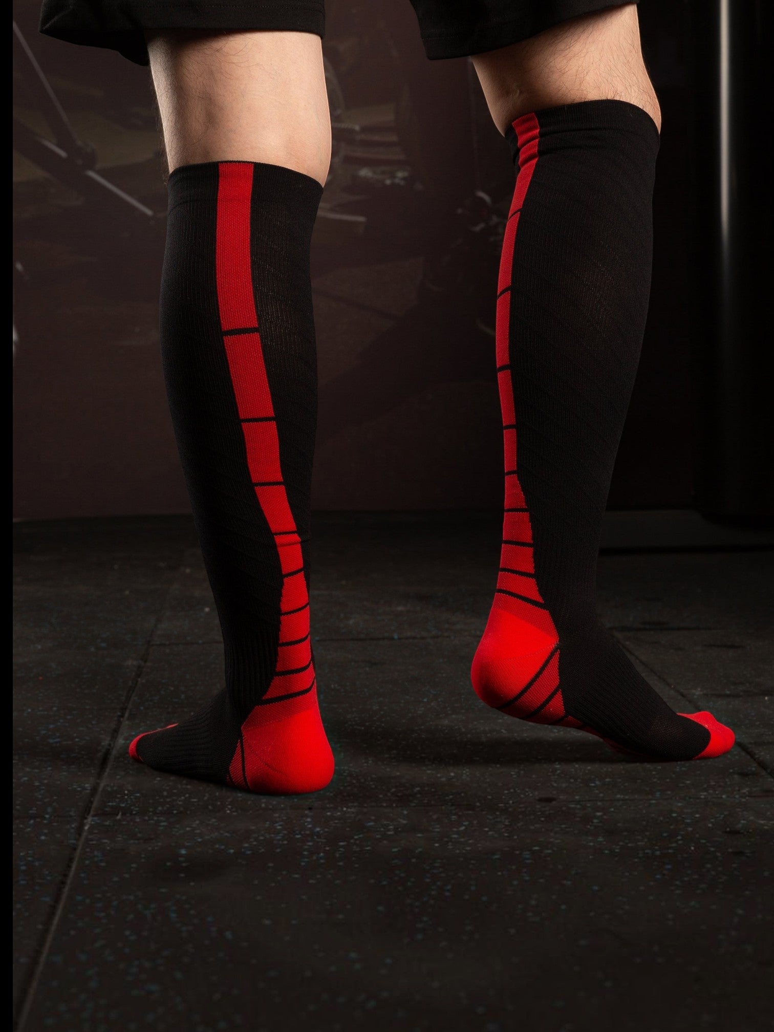Kotyss unisex knee-high compression socks in black and red with seamless design and padded toe and heel support.