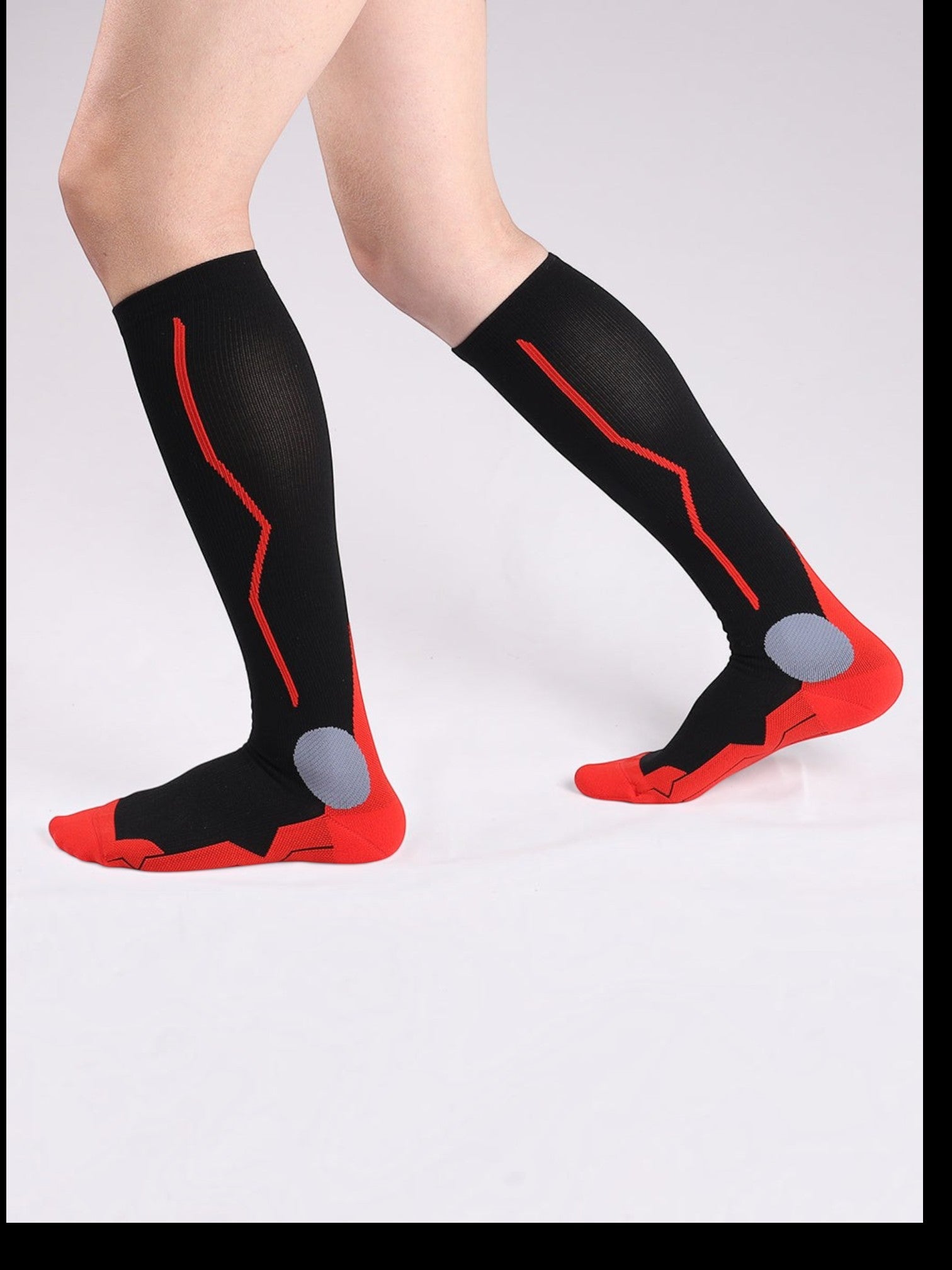 Kotyss unisex knee-high compression socks in black and red with seamless design and targeted padding for support.