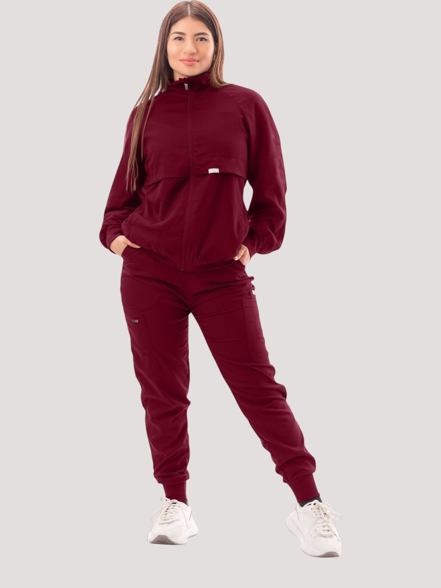 Kotyss women's burgundy scrub jacket and matching pants with a high neck, ribbed cuffs, and functional pockets.