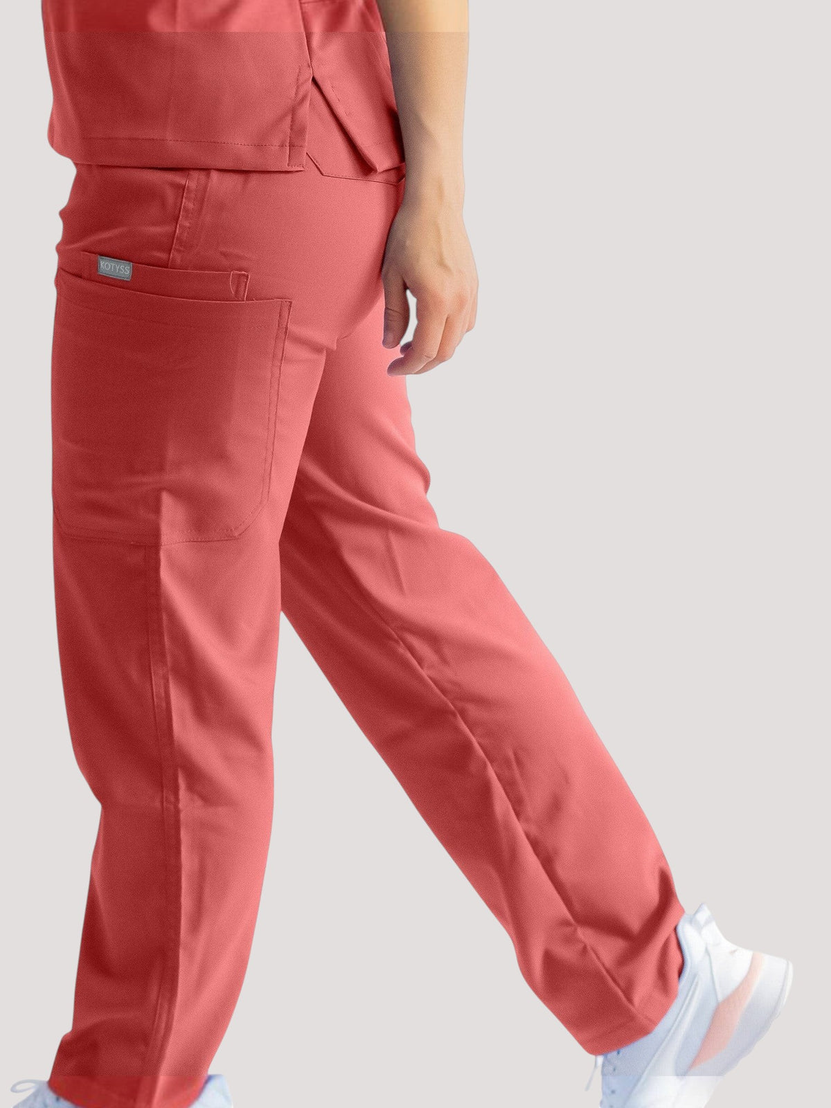 Kotyss straight cut medical scrub pants in coral pink with multiple utility pockets and 4-way stretch fabric