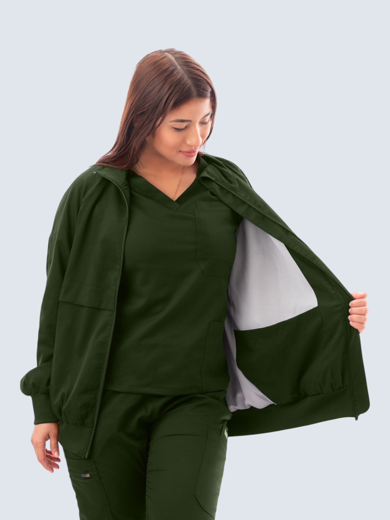 Kotyss women's dark green scrub jacket with a high neck, ribbed cuffs, and a light grey interior lining.