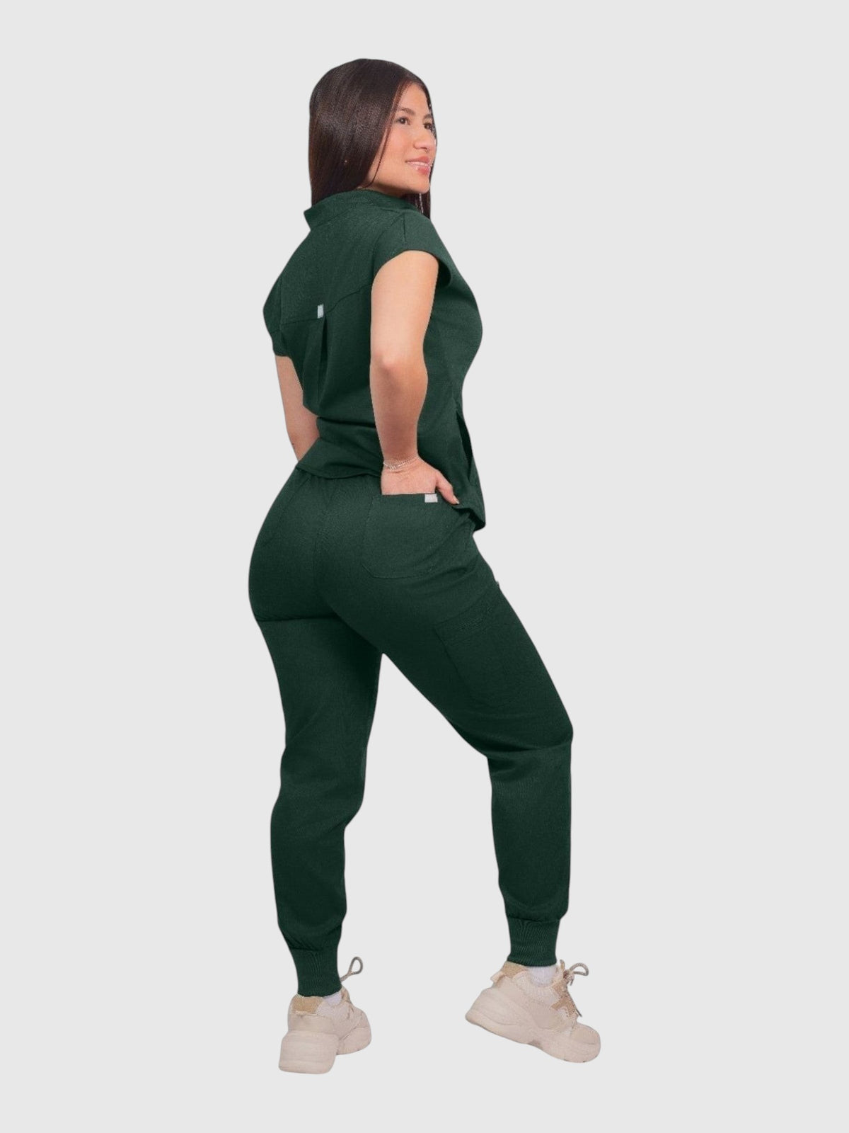 Kotyss women's dark green collared scrub top and jogger set with multiple pockets, worn by a model in a studio.