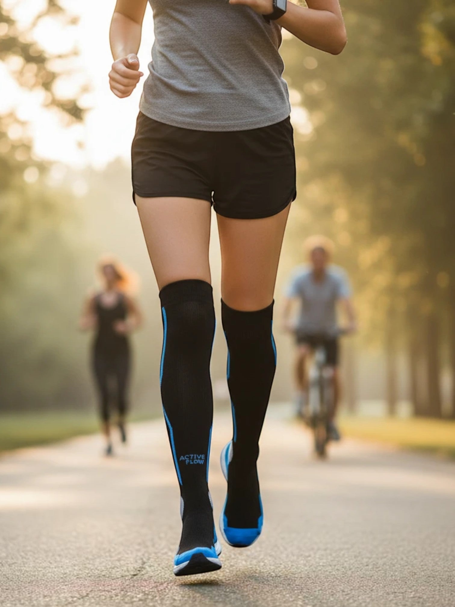 Runner wearing Kotyss knee-high compression socks in black with blue accents during an outdoor workout