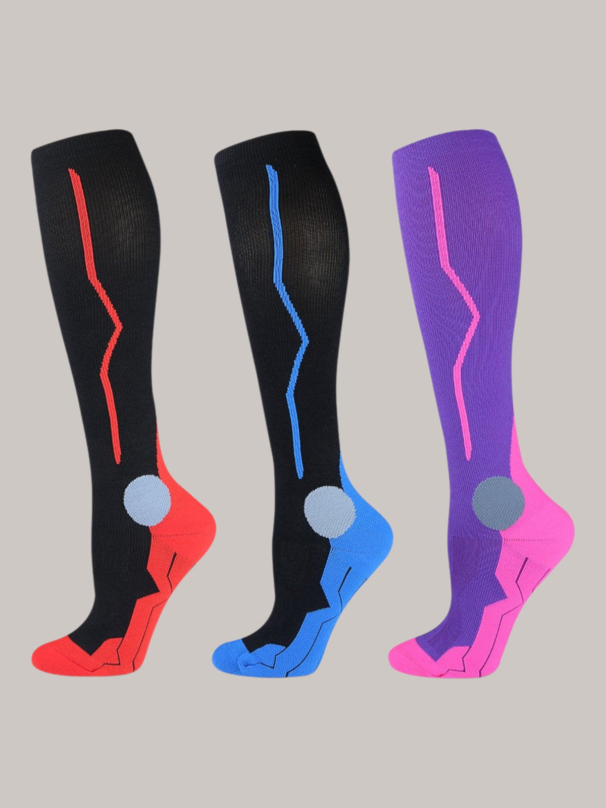 Kotyss knee high compression socks in black with red, black with blue, and purple with pink, featuring padding.