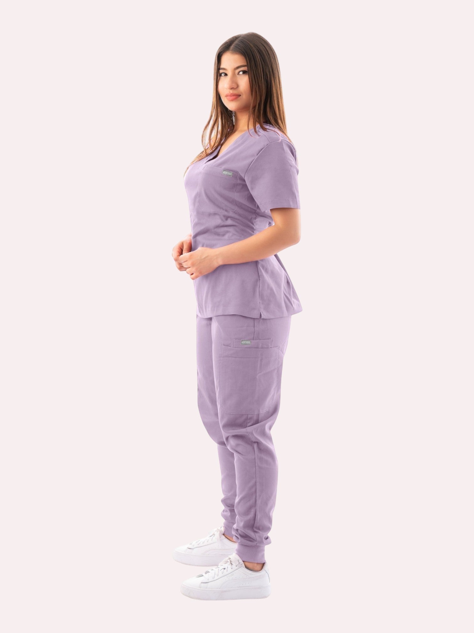 Kotyss women's lavender V-neck scrub top and jogger pants set with multiple pockets worn by a model