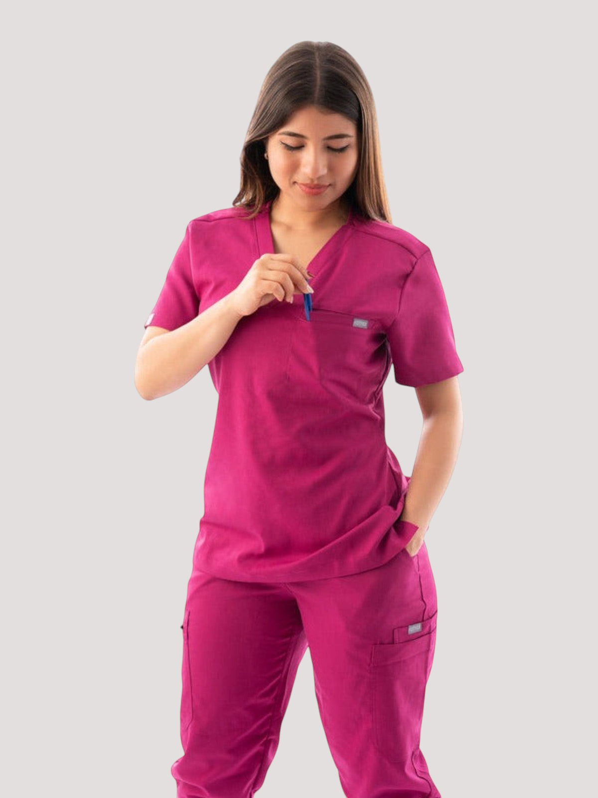 Kotyss women's magenta V-neck scrub top and jogger pants set with multiple pockets on a model