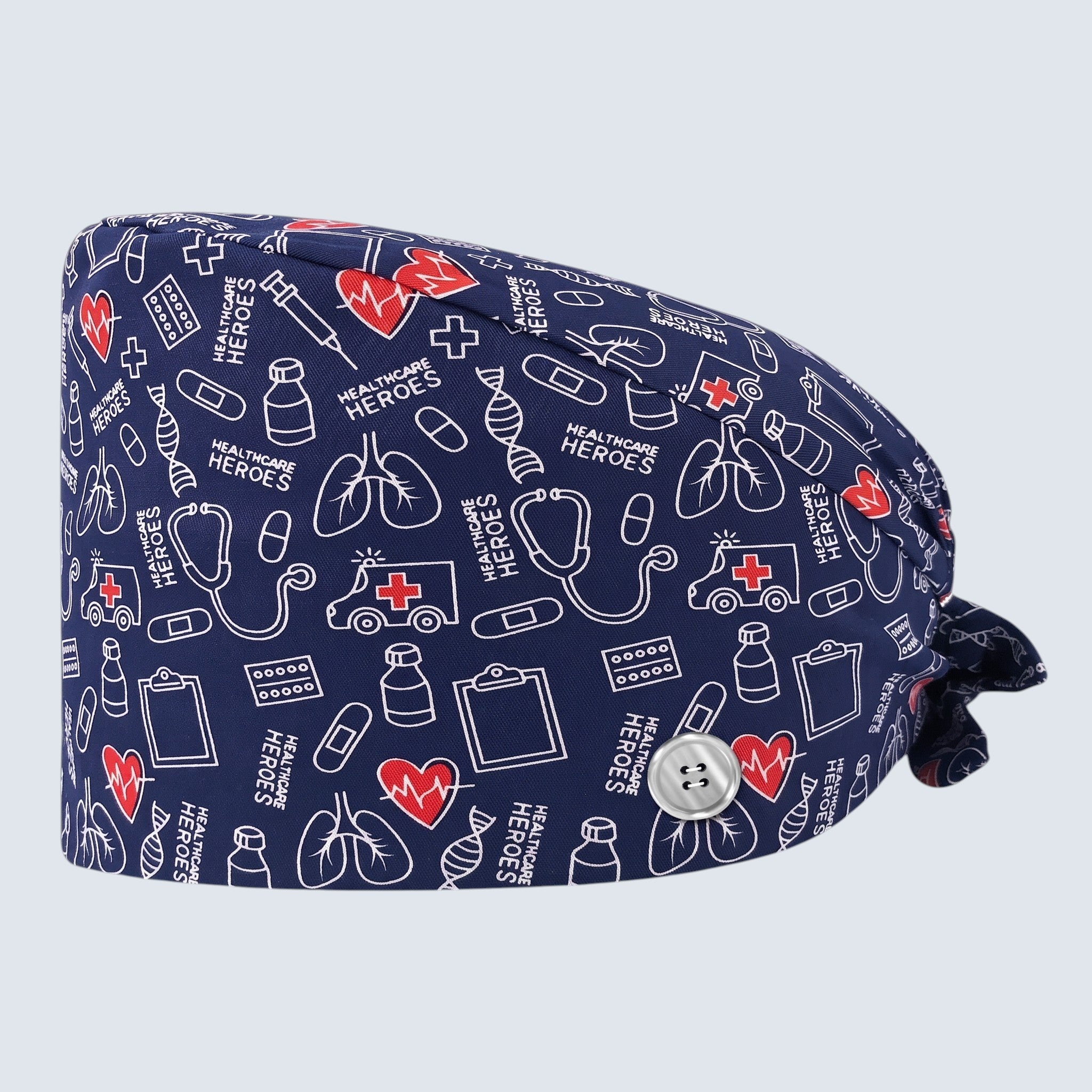 Kotyss unisex scrub cap in navy blue with white medical icons and red hearts, featuring adjustable back tie straps.