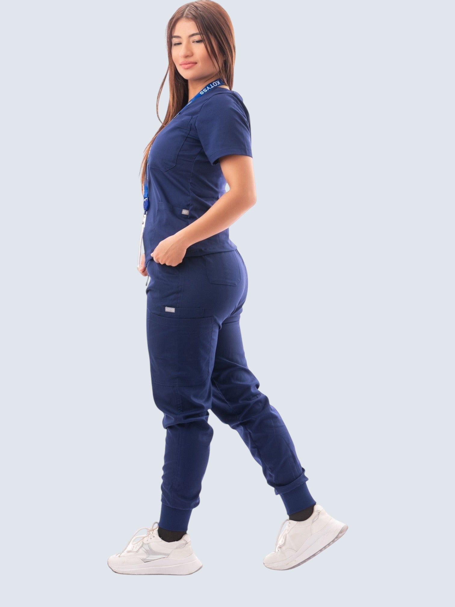 Kotyss women's navy blue V-neck scrub top and jogger pants set with multiple pockets on a model.