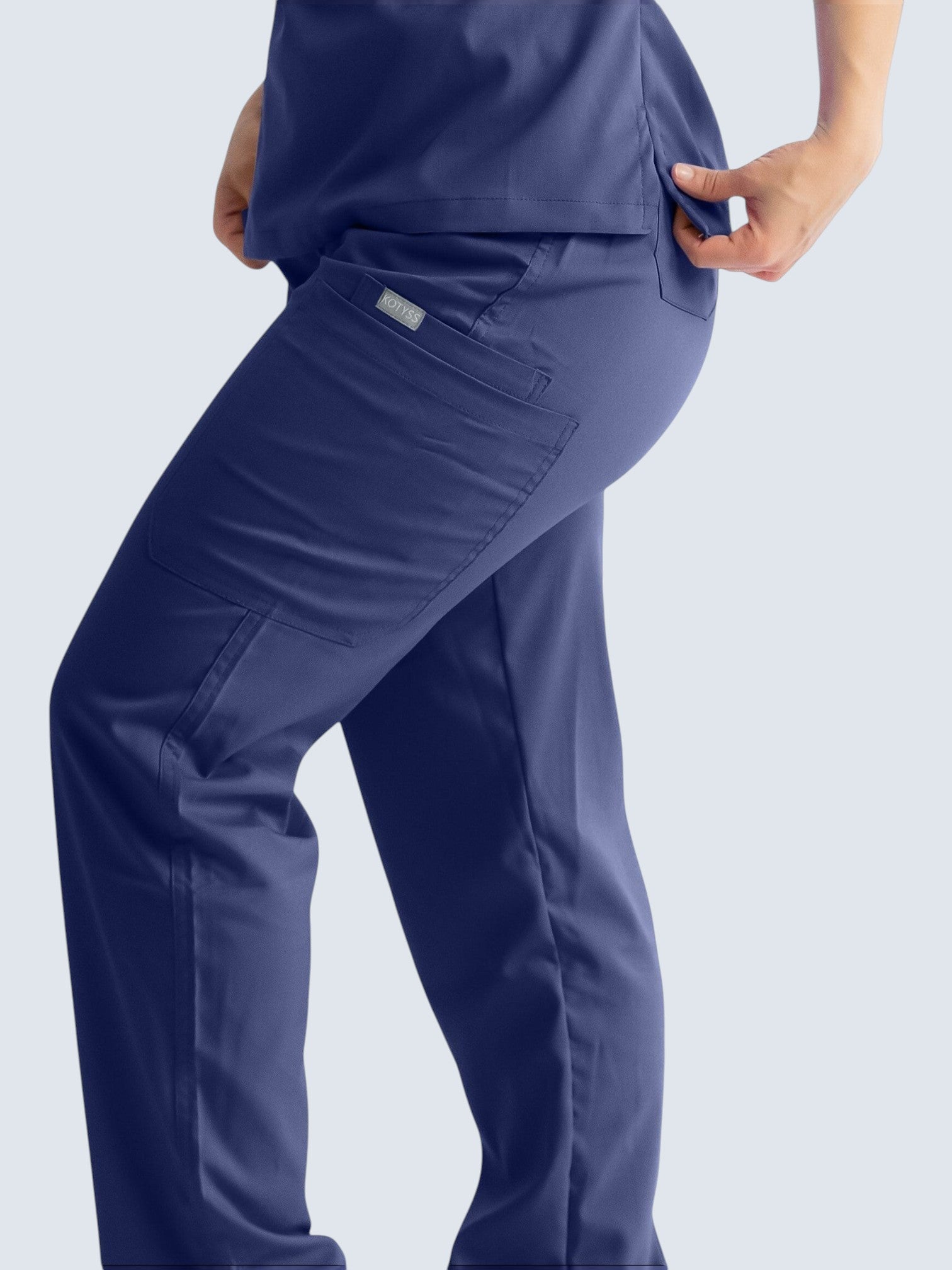 Kotyss navy blue straight cut medical scrub pants with multiple utility pockets and a side view on a model.