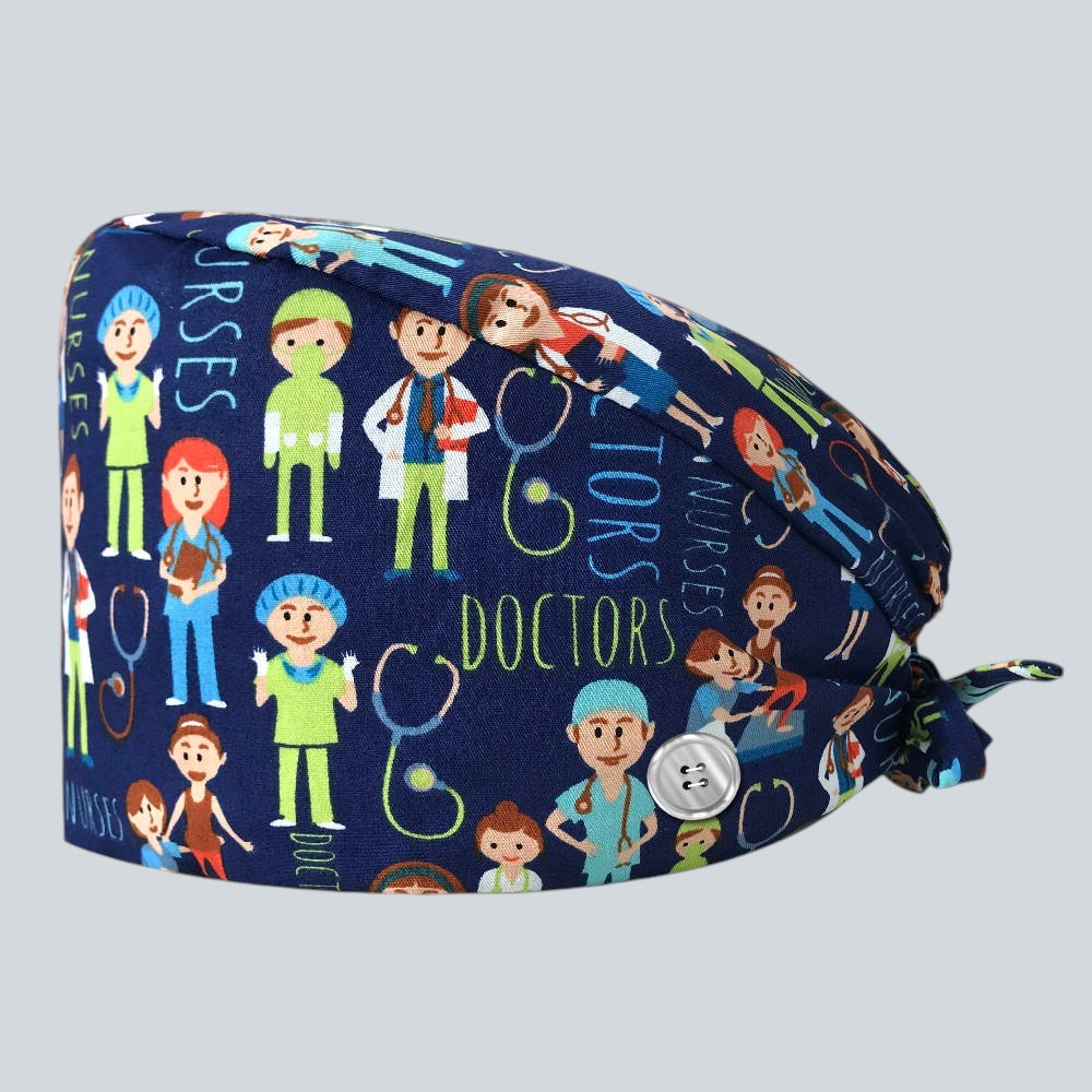 Kotyss unisex scrub cap in navy blue with a colorful medical staff print, featuring adjustable tie straps and buttons.