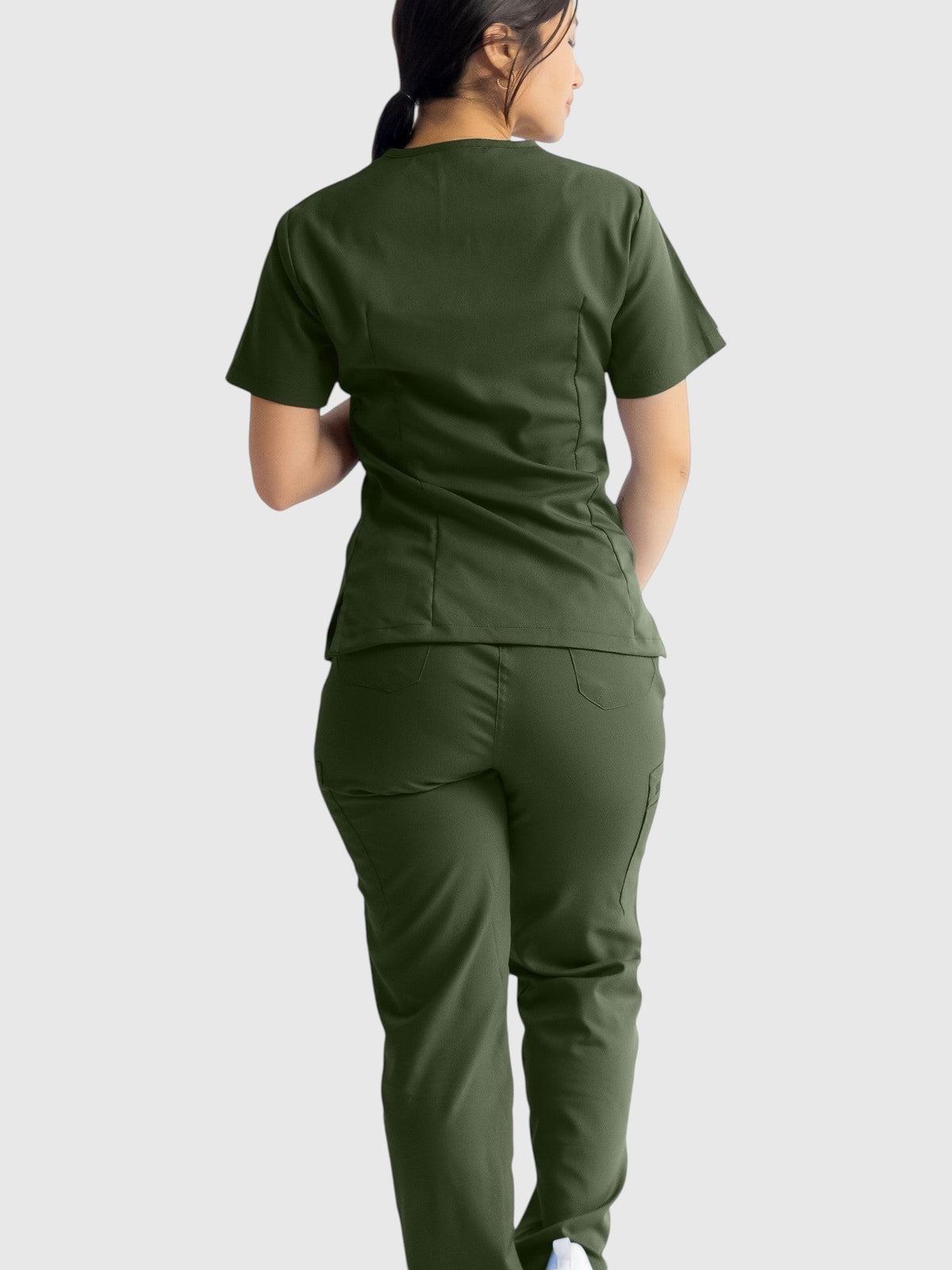 Kotyss olive green straight cut scrub pants and matching top worn by a woman, back view showing pocket details.