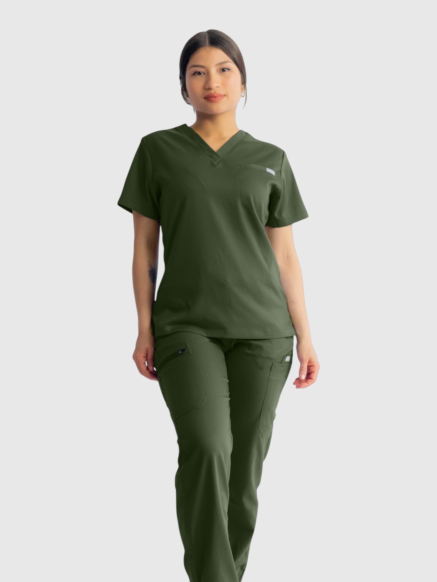 Kotyss olive green straight cut medical scrub pants and matching v-neck top worn by a female model