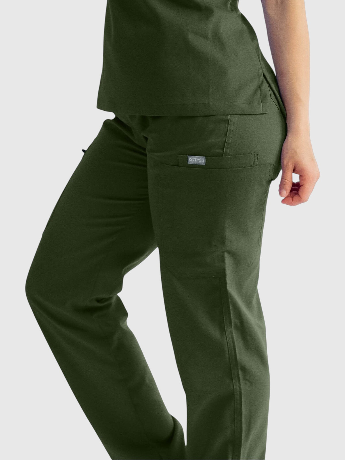 Kotyss olive green straight cut medical scrub pants with multiple utility pockets on a model