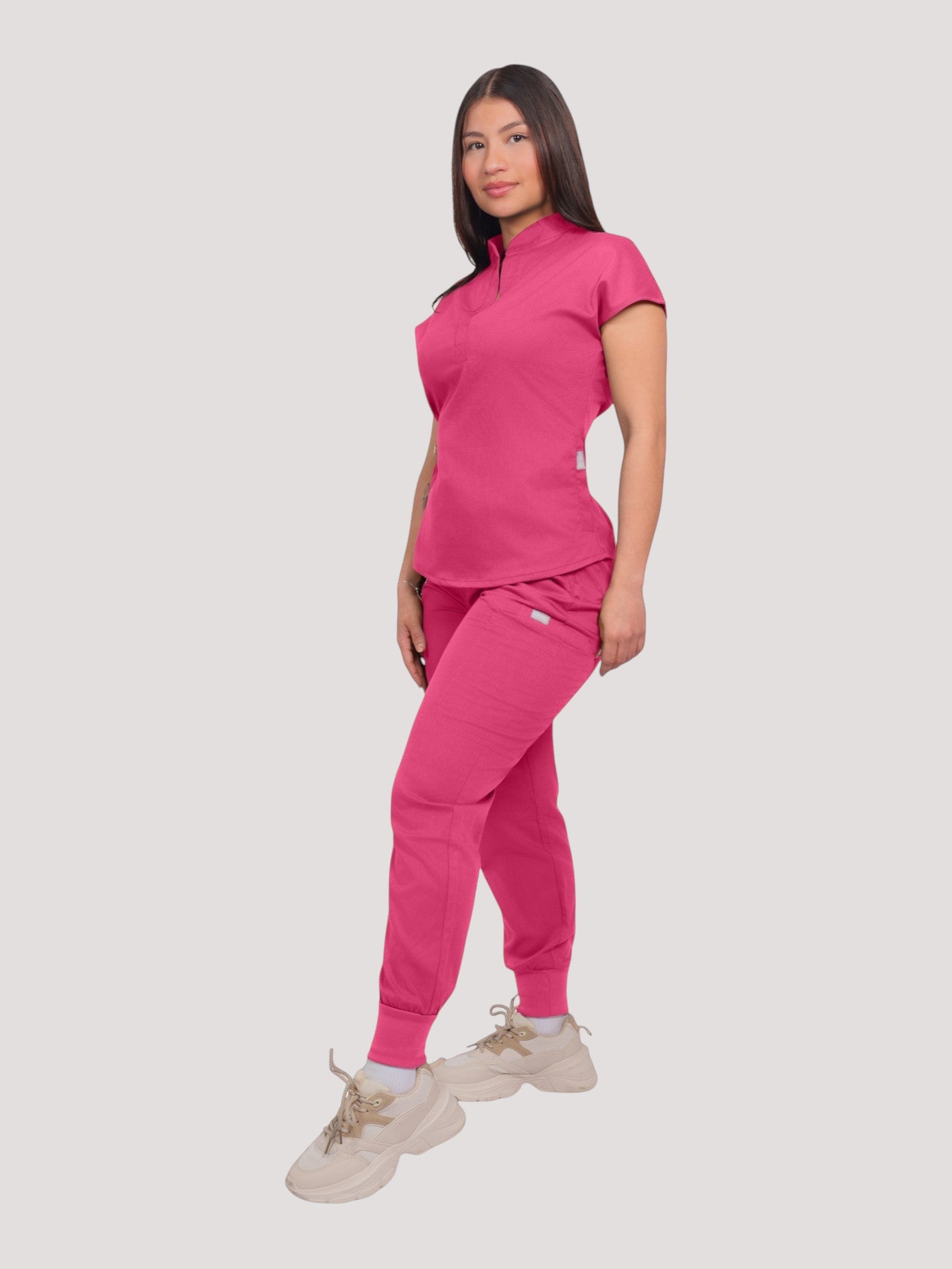 Kotyss women's pink collared scrub top and jogger set in breathable 4-way stretch fabric on a model