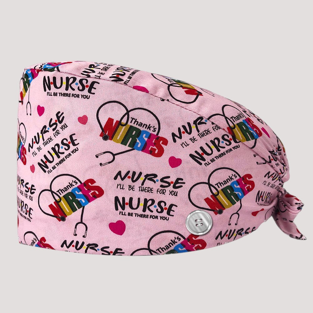 Kotyss pink scrub cap with nurse-themed print, adjustable tie back, and side buttons for mask comfort.