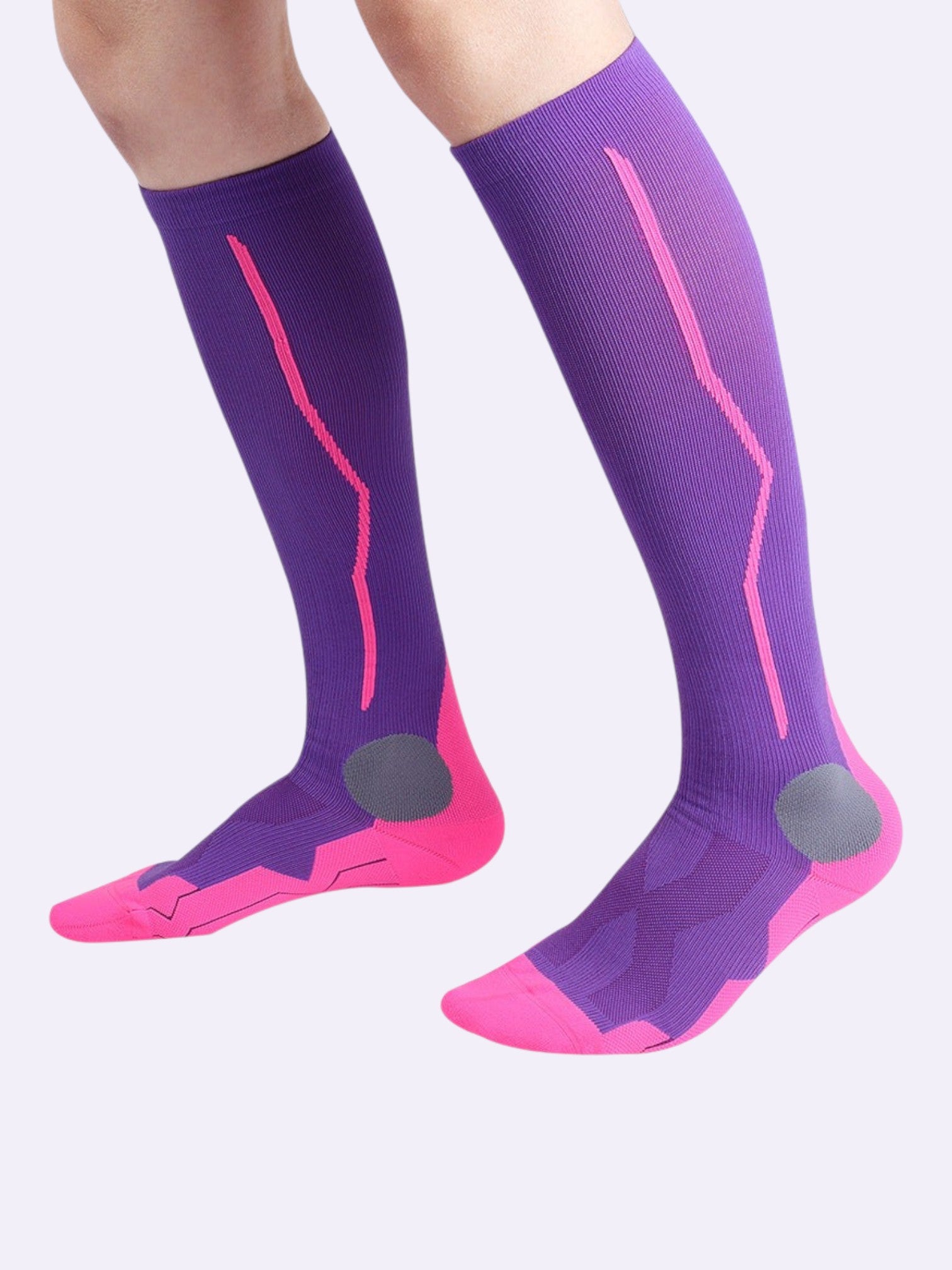 Kotyss purple and pink knee-high athletic compression socks with seamless design and reinforced padding on feet.
