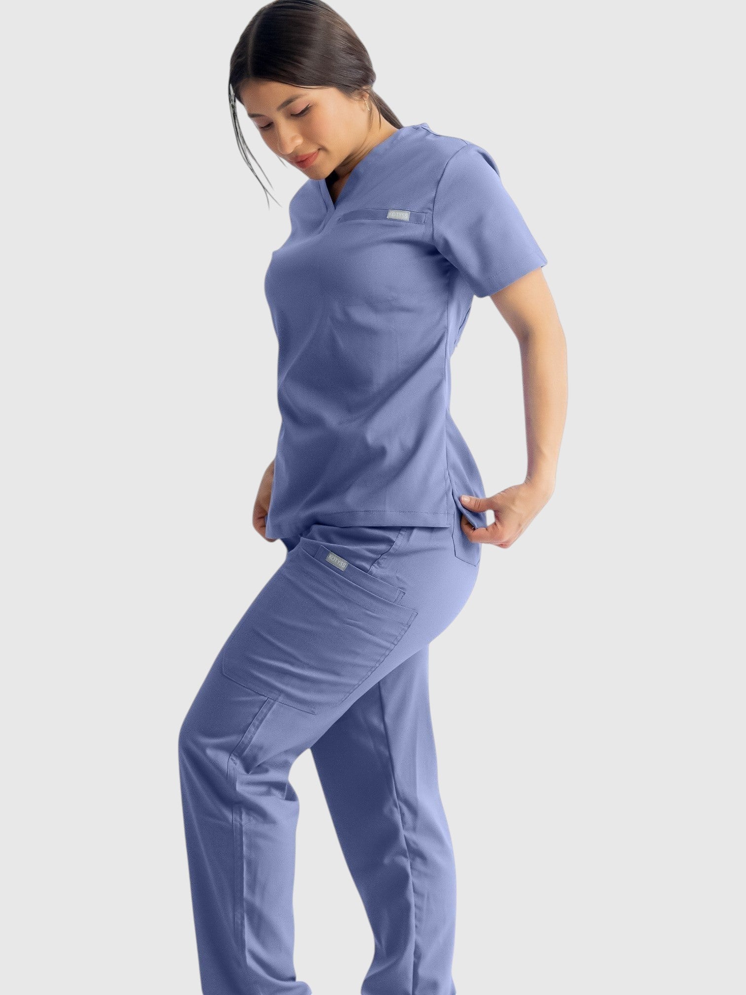 Kotyss model wearing light blue straight cut medical scrub pants and matching top with multiple utility pockets