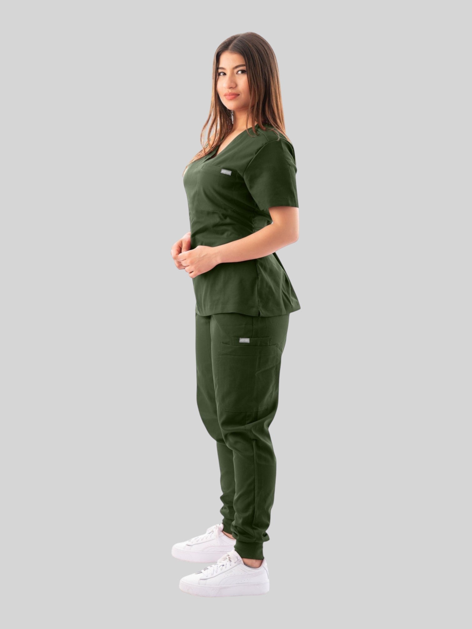 Kotyss women's dark green V-neck scrub top and jogger pants set with multiple pockets on a model